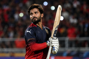 Rajat Patidar standing in cricket stadium with bat during IPL 2026 match for Royal Challengers Bengaluru